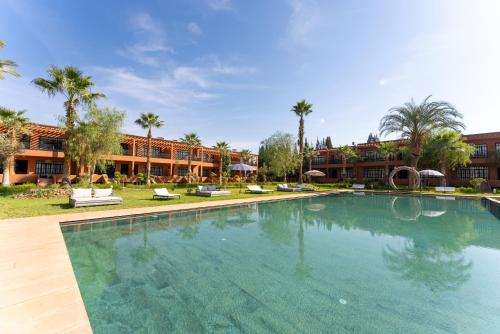 a large swimming pool in a resort with palm trees at MVIEW Villas in Marrakech