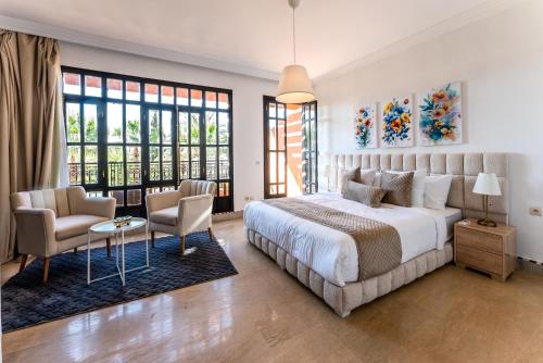 a bedroom with a large bed and two chairs at MVIEW Villas in Marrakesh