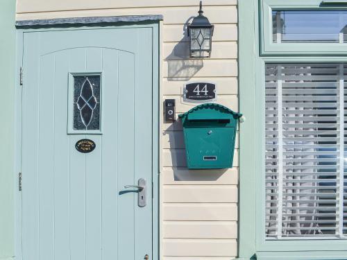a door to a house with a trash can next to it at Lowey's Harbour Cottage in Bridlington