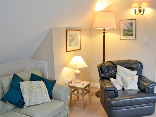 a living room with a couch and a chair at Fairlaw Garden Cottage in Reston