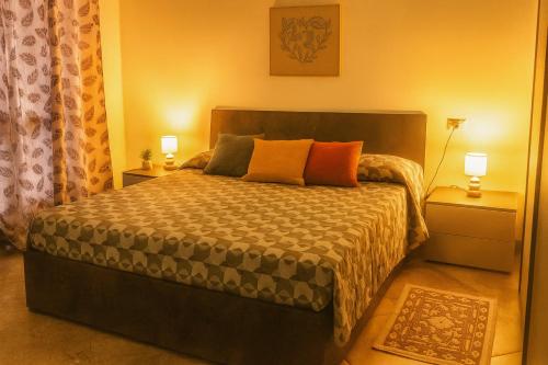 a bedroom with a bed with two night stands and two lamps at Sa Domittedda in Sassari