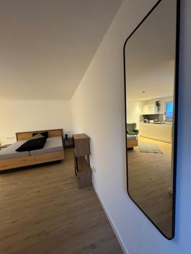 a mirror in a room with a bed and a bedroom at Ferienwohnung Tee - Time - Lodge und Kirsch - Kiste in Momlingen