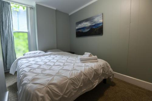 a bedroom with a bed with towels on it at Fully Remodeled, Charming Victorian Home in Rochester
