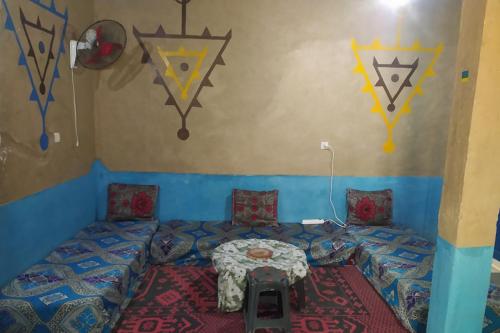 a room with a bed with a table in it at Desert house in Merzouga