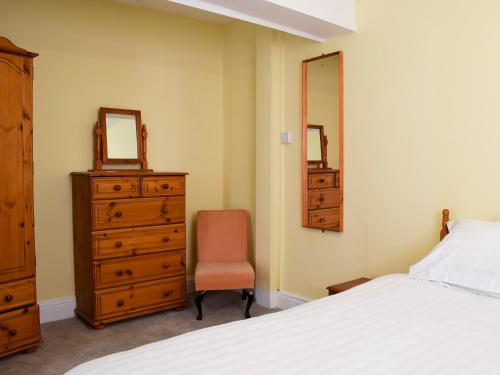 ein Schlafzimmer mit einem Bett, einer Kommode und einem Spiegel in der Unterkunft Alexandra Cottage in Windermere