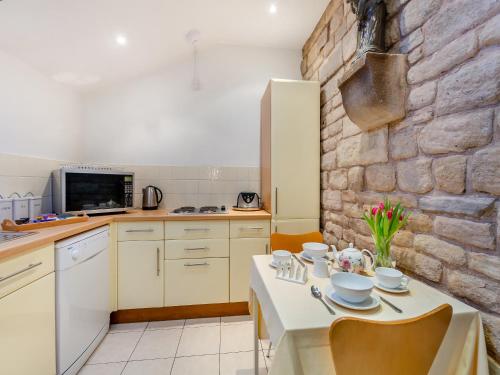a kitchen with a table and a stone wall at Irishman's Tower in Riley Green