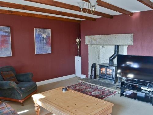 a living room with a fireplace and a tv at Oak Cottage-16498 in Catcleugh
