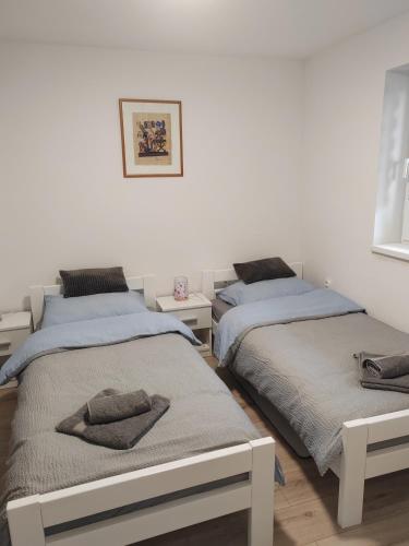 a bedroom with two beds with towels on them at Sobe i apartman Berecz in Kopačevo