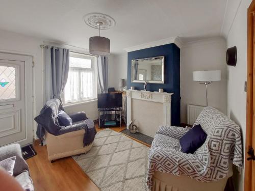 a living room with two chairs and a mirror at Amberley Cottage in Alfreton