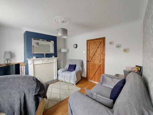a living room with a couch and a chair at Amberley Cottage in Alfreton