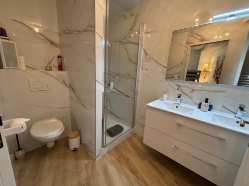 ein Badezimmer mit Dusche, Waschbecken und Toilette in der Unterkunft ARMONA in Brides-les-Bains