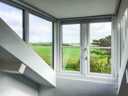 a room with a window with a view of a field at Hempstead End in Lessingham