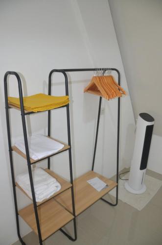 a towel rack with three shelves in a room at Toba-A-Scape in Ambarita