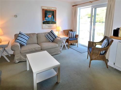 a living room with a couch and chairs and a table at Tarquins in Fowey