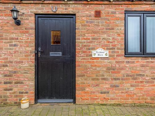 Runcton HolmeにあるArchway Barn - E3864の煉瓦造りの建物の黒い扉