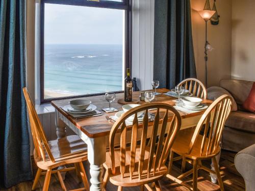 a dining room table with chairs and a large window at Bishop Rock - Grl in Trevilley