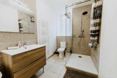 a bathroom with a sink and a shower and a toilet at Appartement face aux thermes de vals WIFI-Parking gratuit in Vals-les-Bains