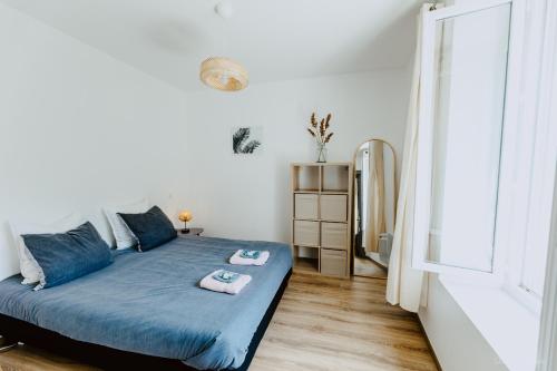 a bedroom with a bed with blue sheets and a window at Appartement face aux thermes de vals WIFI-Parking gratuit in Vals-les-Bains