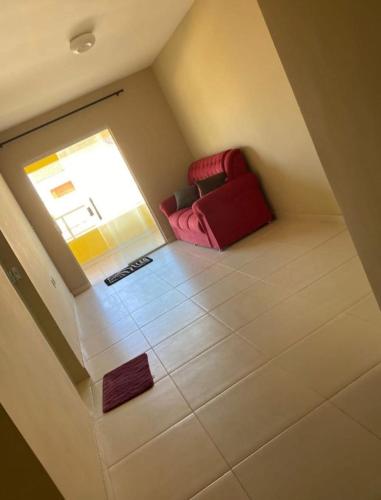 a red couch sitting in the corner of a room at Iane Raquel Bezerra Barbosa in Tamandaré