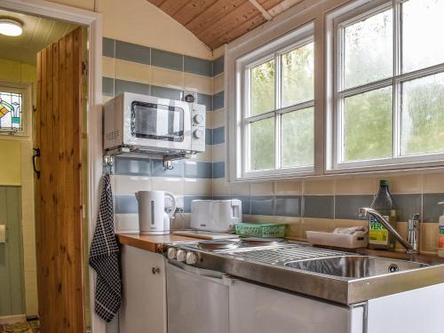 a kitchen with a sink and a microwave at Field View in St Austell