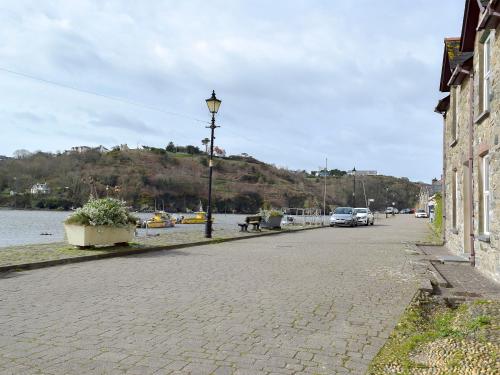 Una calle empedrada junto a un río con una farola en Yorke Villa, en Fishguard