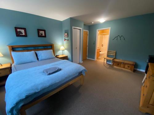 a bedroom with a large bed with blue walls at Timberline Lodge by StayIn in Fernie