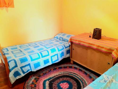 Un dormitorio con dos camas individuales y una alfombra. en Departamento Dharma, en Capilla del Monte