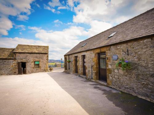 an old stone building with a pathway next to it at Lathkill Cottage in Bakewell