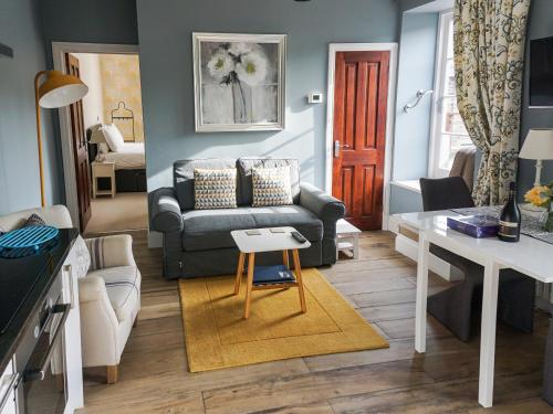 a living room with a couch and a table at Bookkeepers Place in Bakewell