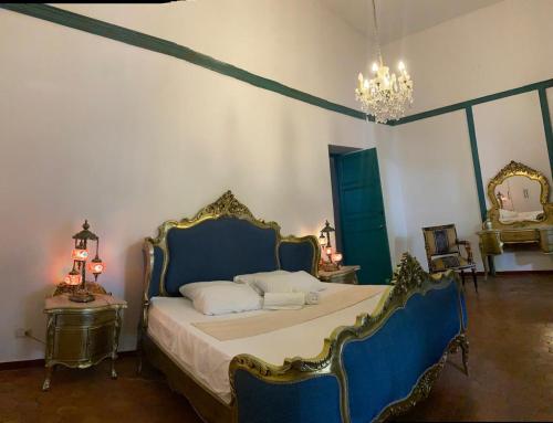 a bedroom with a bed with blue and gold furniture at Paraíso Real in Buga