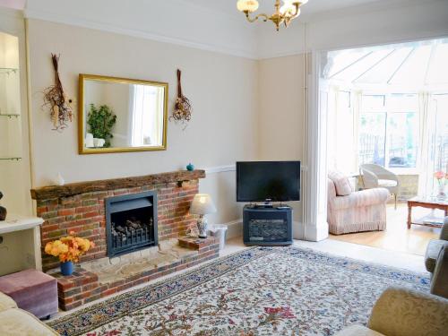 a living room with a fireplace and a television at Ivy Cottage in Westgate-on-Sea