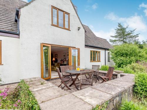 een terras met een tafel en stoelen voor een huis bij Cwmfron House in Llanidloes