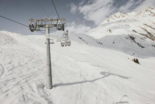 a ski lift on top of a snow covered mountain at Zalbander Chalets in Silbertal