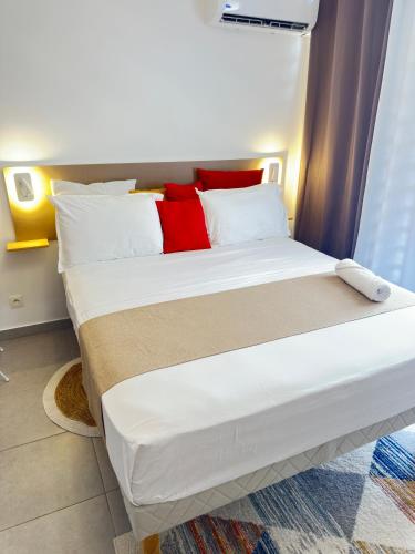a bedroom with a bed with white and red pillows at Appart de standing - Séjours professionnels et privés in Cayenne