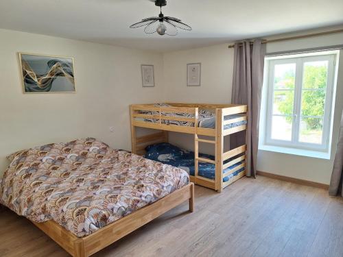 a bedroom with a bunk bed and a window at Chez Riri in Saints-Geosmes