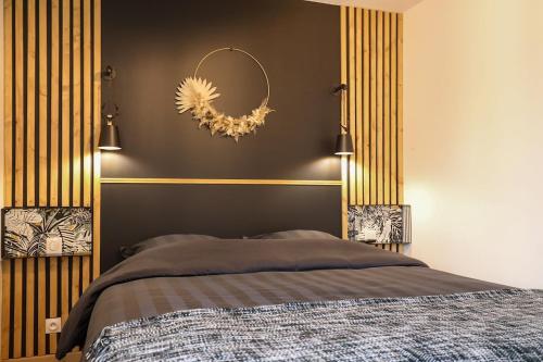 a bedroom with a bed and a wreath on the wall at La Ptite Maison Ardennaise in Rilly-sur-Aisne