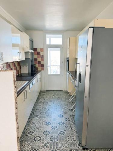 eine Küche mit einem Kühlschrank und Fliesenboden in der Unterkunft Chambre Privée Cosy- Dans Appartement Moderne en Colocation - F1-1 in Talence