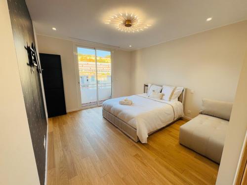 Un dormitorio con una cama grande y un sofá. en LE PALAIS DIANE - Apt cosy, Moderne et Climatisé, en Niza