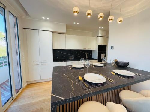 Una cocina con una mesa con platos y copas de vino. en LE PALAIS DIANE - Apt cosy, Moderne et Climatisé, en Niza