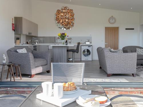 ein Wohnzimmer mit Tisch und Stühlen und eine Küche in der Unterkunft The Hideaway -Ukc3844 in Ticknall