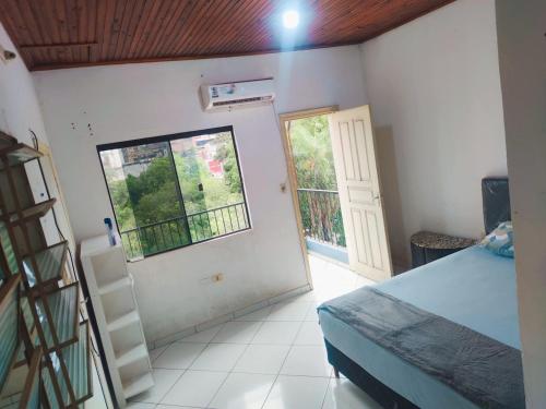 1 dormitorio con cama, ventana y escalera en Alojamiento San Blas, en Ciudad del Este