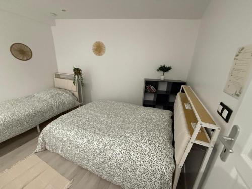 une chambre avec deux lits jumeaux dans une pièce dans l'établissement Appartement Villiers sur Morin proche de Disneyland, à Villiers-sur-Morin