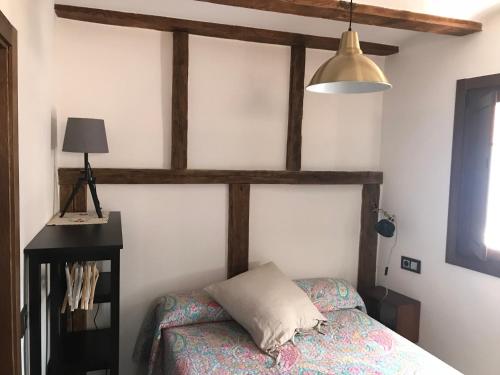 a bedroom with a bed and a lamp at estudio judería in Sigüenza