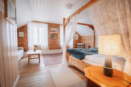 a bedroom in a log cabin with a bed and a lamp at Helgaker Gård in Gran
