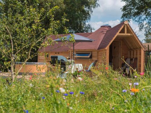 a log cabin with a red roof at Dol Y Mynydd The Mountain Meadow - Cottage in Llangernyw