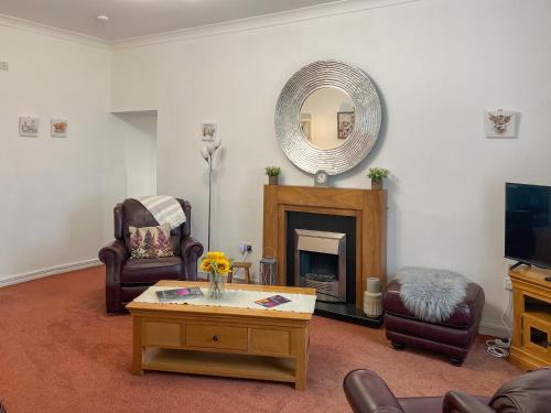 een woonkamer met een open haard en een spiegel bij Muirston Farmhouse - Uk44977 in Ochiltree