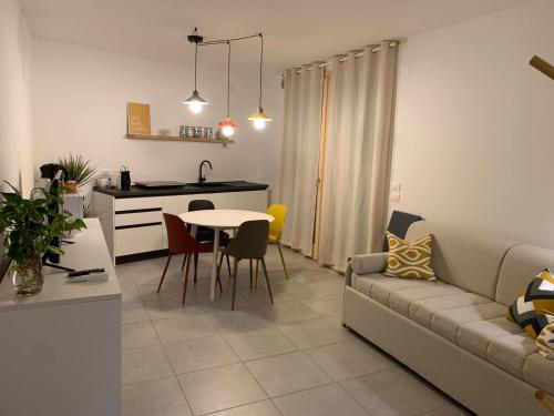 ein Wohnzimmer und eine Küche mit einer Couch und einem Tisch in der Unterkunft Appartamento 21 - Smart Apartment nel centro di Segusino, vicino le colline del Prosecco in Sequsino