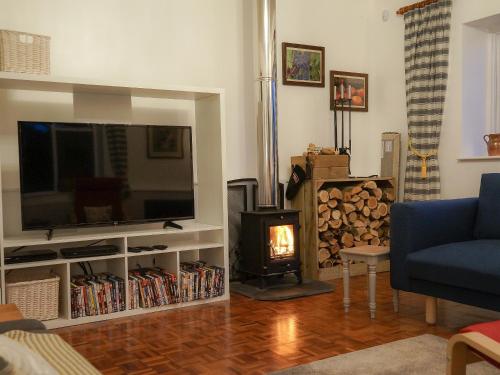 a living room with a television and a fire place at Burrills View in Horderley