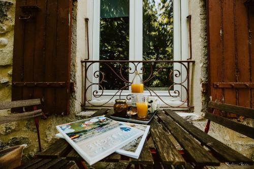 een tafel met twee glazen sinaasappelsap op een veranda bij La bogue in Vals-les-Bains