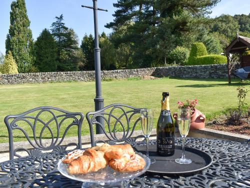 a table with a bottle of wine and a plate of bread at Keepsake View in Two Dales